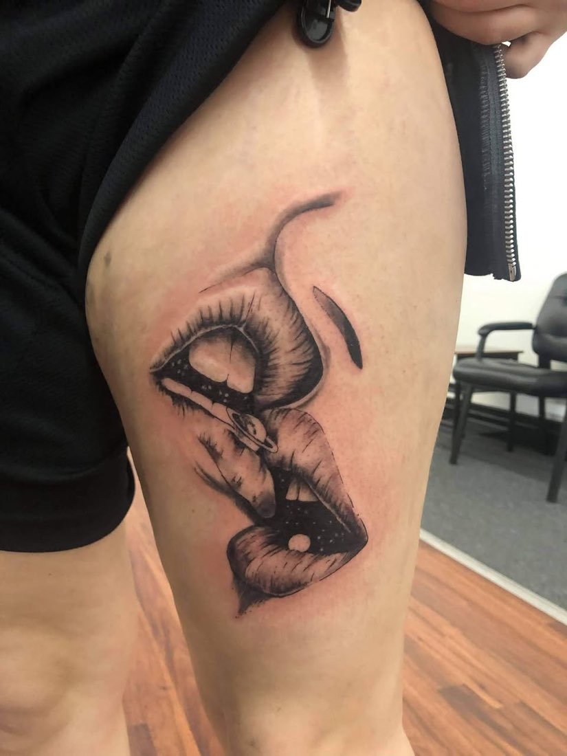 Black and grey thigh tattoo of an eye and lips
